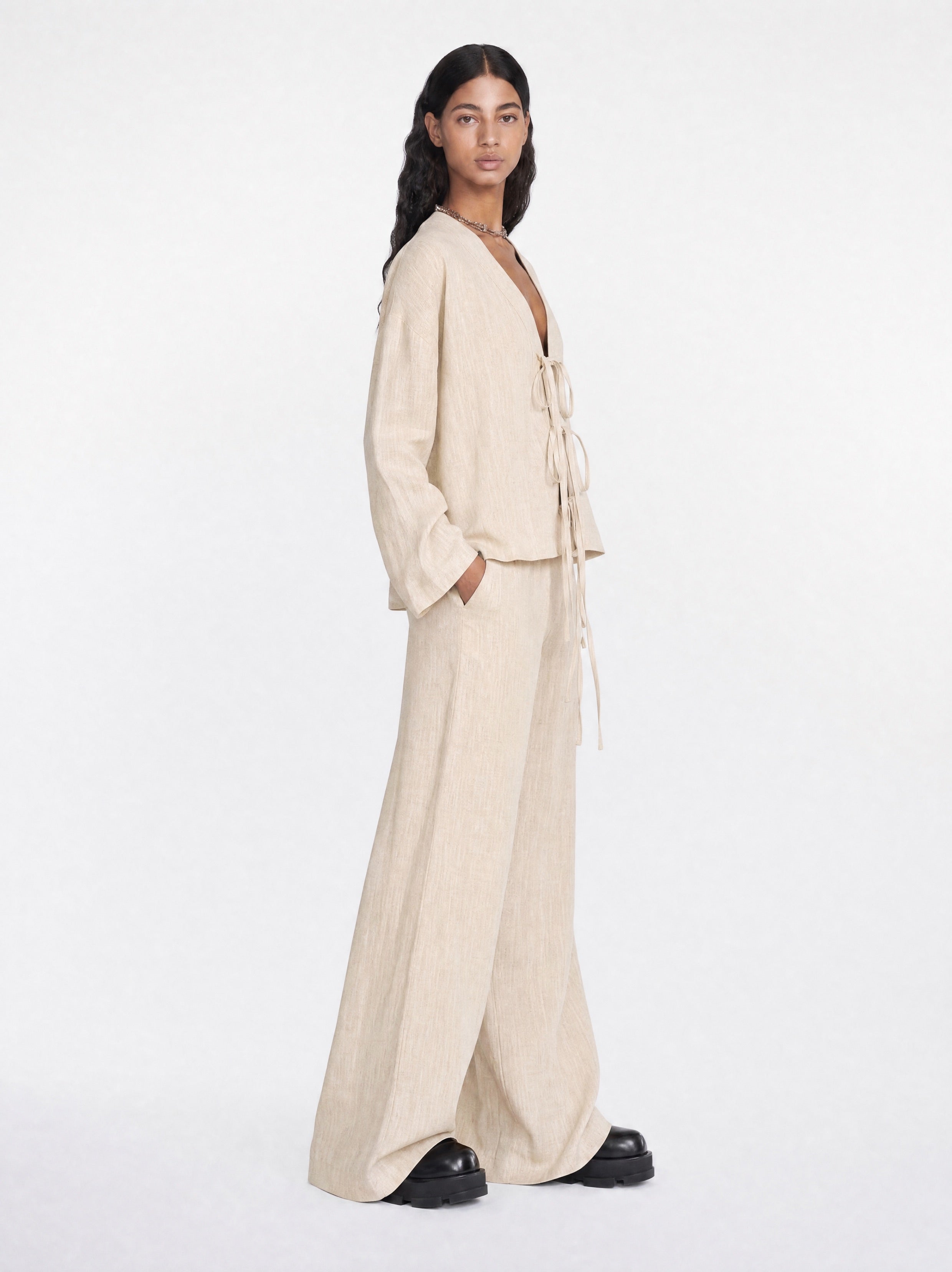 Woman wearing a beige outfit on a white background