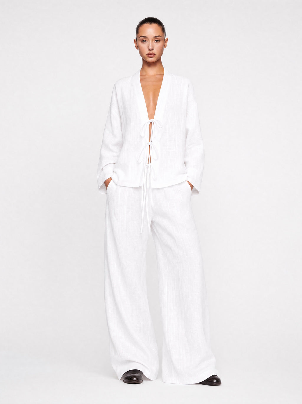 Person wearing a white outfit on a plain background