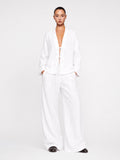 Person wearing a white outfit on a plain background