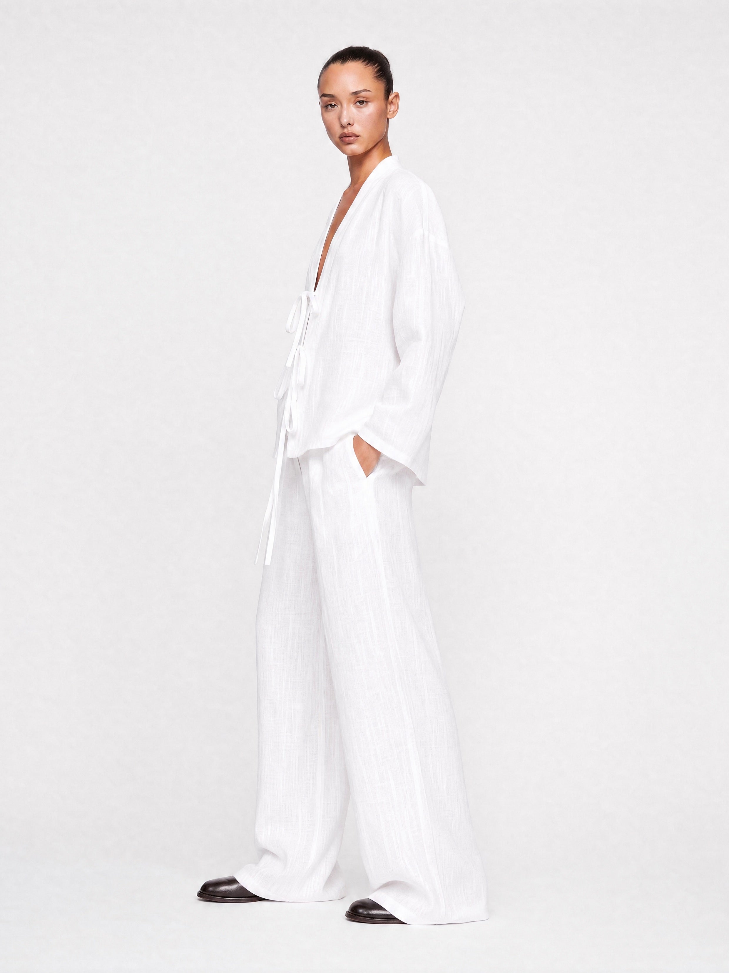 Person wearing a white outfit on a plain background