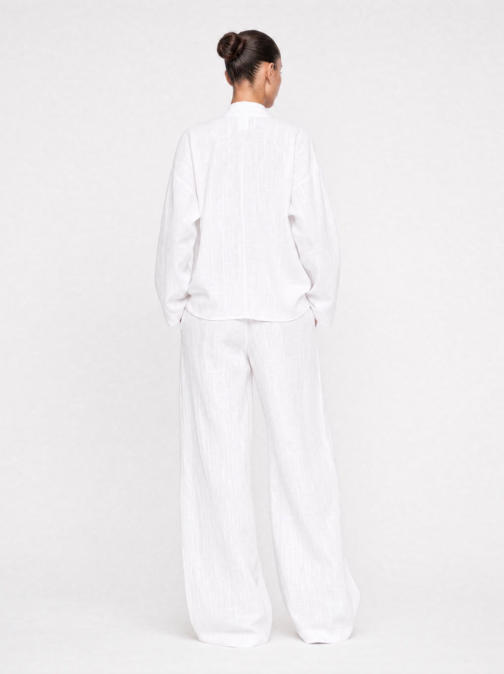 Person wearing a white outfit on a plain background