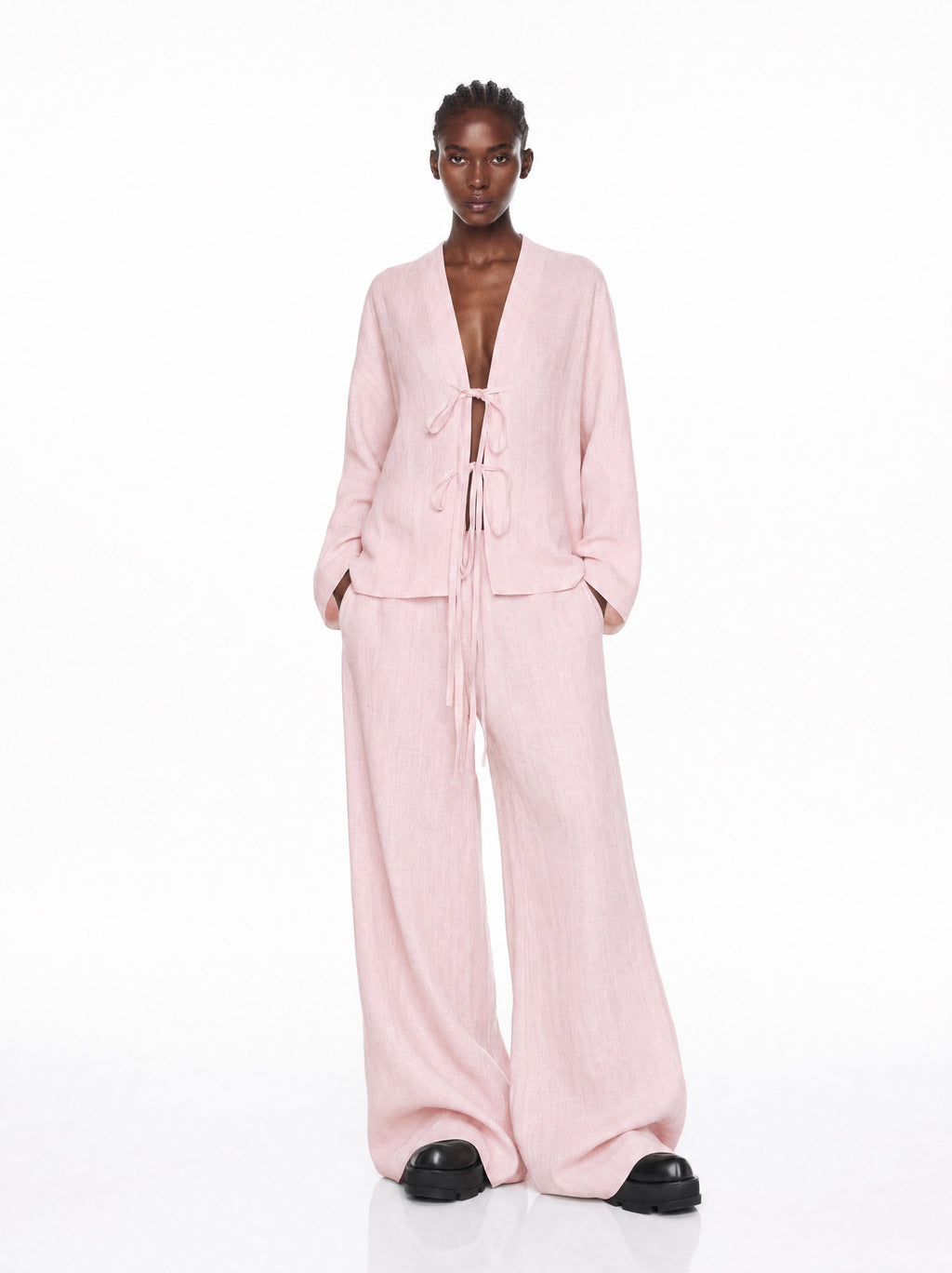 Person wearing a pink outfit on a white background