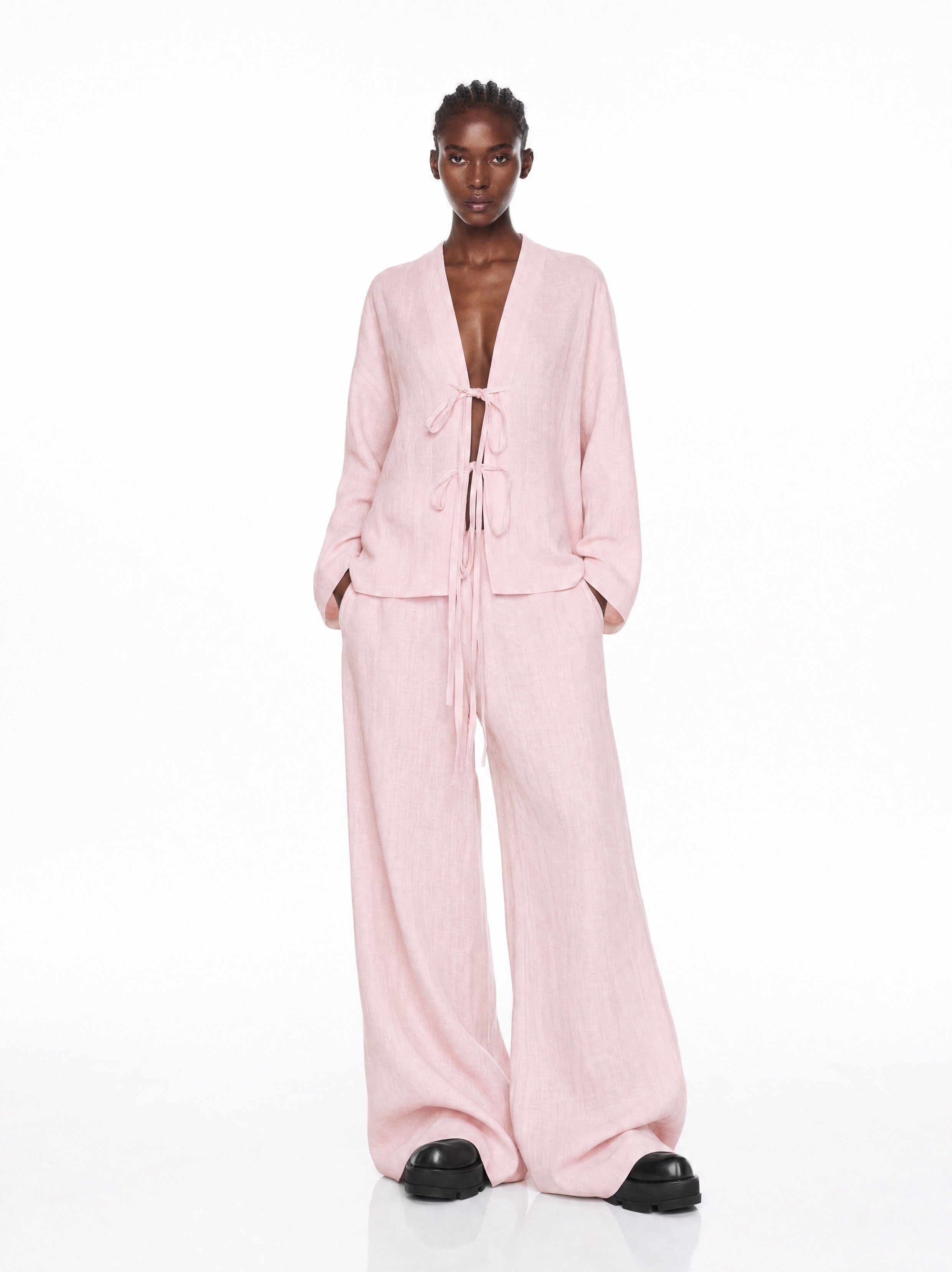 Person wearing a pink outfit on a white background